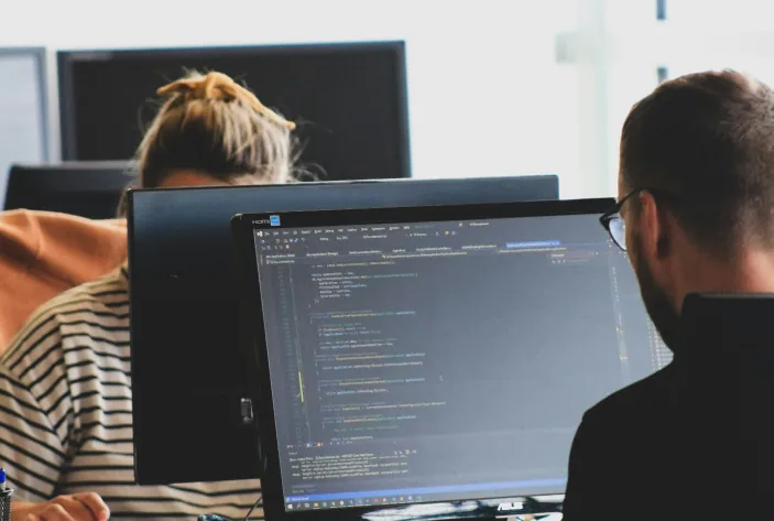 Developers working at monitors with code on screen